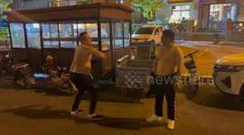 Men fight playfully with shirts on roadside in Hebei Province