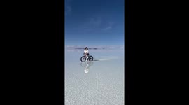 Woman Rides Bike At Bolivia's Salar de Uyuni