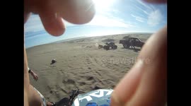 Biker misjudges dune jump and lands on friend