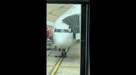 Pilots lean from cockpit to clean plane windscreen