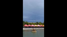 Beachgoers capsize with wobbly Thai basket boat in sea