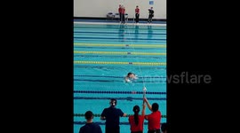 Bizarre moment cat falls from ceiling into pool, disrupting swimming competition