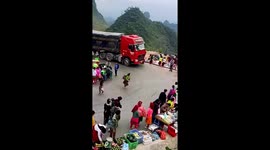 Articulated lorry struggles on sharp bend lined with market stalls