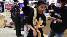 Visitors handling very large python snakes at Pet Expo in Bangkok, Thailand