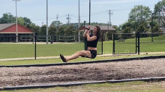 Sexy girl bounces on the zipline with her hair flowing behind her.