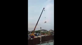 Crane operator lifts drunk man on pallet swing in Solovei-Kliuch, Primorye, Russia