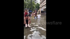 Locals wade through waist-deep floodwater as torrential rain hits Wuhan