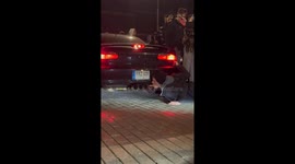 Daring lad lights cigarette with a car’s fire exhaust