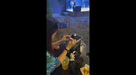 Girls make tiny hat and put it on friendly bird that flew to them at bar