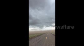 US: A tornado-warned storm blows dust into the air near Dickens