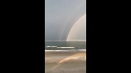 Double rainbow with a horizontal lighting strike though it, on Daytona Beach during a storm.