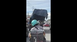 Riders avoid truck with unstable metal cargo in Manila, Philippines