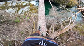 thrill-seeker jumps off hanging log above frosty natural pool in the Pacific Northwest