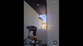 Delivery Man Straightens Up Pile of Packages