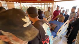 Wounded Palestinian youth who lost his mother in Israeli attack near aid distribution site in Rafah attends funeral on hospital bed