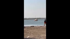 Kayakers try to retrieve tent being blown across lake