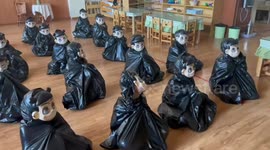 Fathers try to identify their masked children sitting on the floor in Shandong, China