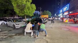 Three men lift parked car to clear path in Anhui, China
