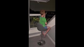 Father films son on balcony with lightning strikes in background in London, United Kingdom
