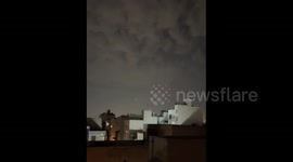 Tracer rounds and defense flares illuminate the night sky over Tehran