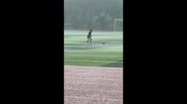 Inspiring moment boy plays football amid heavy rain