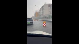 Road barriers float along street during floods in China