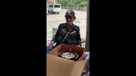 Office staff give security guard working on his birthday with a surprise cake