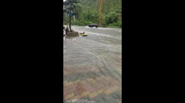 Children enjoy flooded street with inflatable boat during rainstorm in Guizhou, China