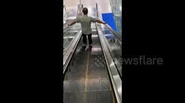 Man appears to float down escalator in bizarre optical illusion