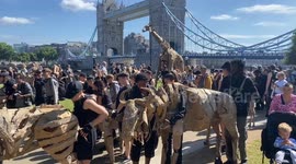 Herds of animal puppets pass near Tower Bridge in London