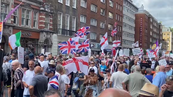 Right-wing protesters throw a smoke bomb and chant at a person displaying a Palestinian flag outside her apartment