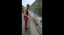 Pole dancer wows with fearless air walk, balancing horizontally over scenic water