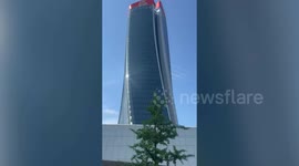 Giant sign at top of Milan skyscraper partially collapses