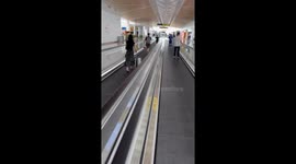 Bungling passengers walk the wrong way on airport travelator