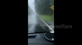 US: Navigating a flooded road during a heavy downpour