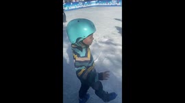 Child struggles and falls during first ice skating attempt in Santiago, Chile