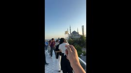 A seagull catches cheese in slow motion on a rooftop cafe in Istanbul, with stunning views of the city in the background.