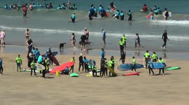Heatwave begins, UK Weather, Beach goers, lifeguards in the shade, chilling in the waves, Fistral Beach, Cornwall, UK
