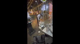 Kind security guard shelters stray cat from rain storm