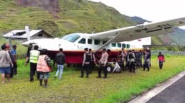 Airport staff push plane after its tyre burst and skidded off runway