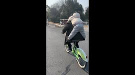 A Girl and Her Grandfather Ride a Bicycle Together