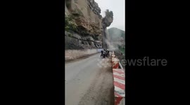 Rockslide sends passing motorists fleeing as huge boulders block road in China