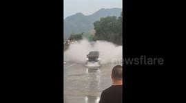 Reckless driver speeds through large puddle only to rear-end car moments later