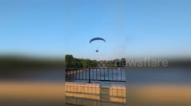 Paramotor crashes into power lines and plunges into river
