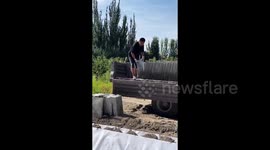 Skilled worker tosses concrete slabs off truck with incredible precision