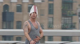 Man shelters under paper bag during heavy rain in London with weather warnings for rain and thunderstorms in place