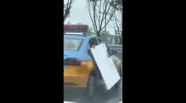 Taxi passengers seen holding white board outside car