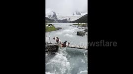 Herder on horseback plunges into river whilst crossing narrow bridge in China