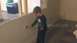 Kids gets a chance to help with demolition and wrecks a wall with a hammer