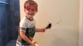 a KID HAMMERING a wall during a home construction project and making a hole